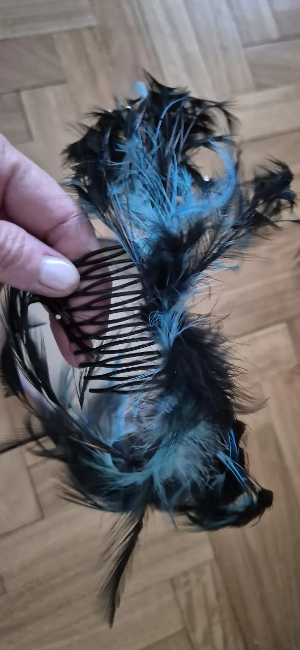 Peine decorado con plumas negras y turquesas, ideal para darle un toque especial a tu peinado en fiestas o eventos.