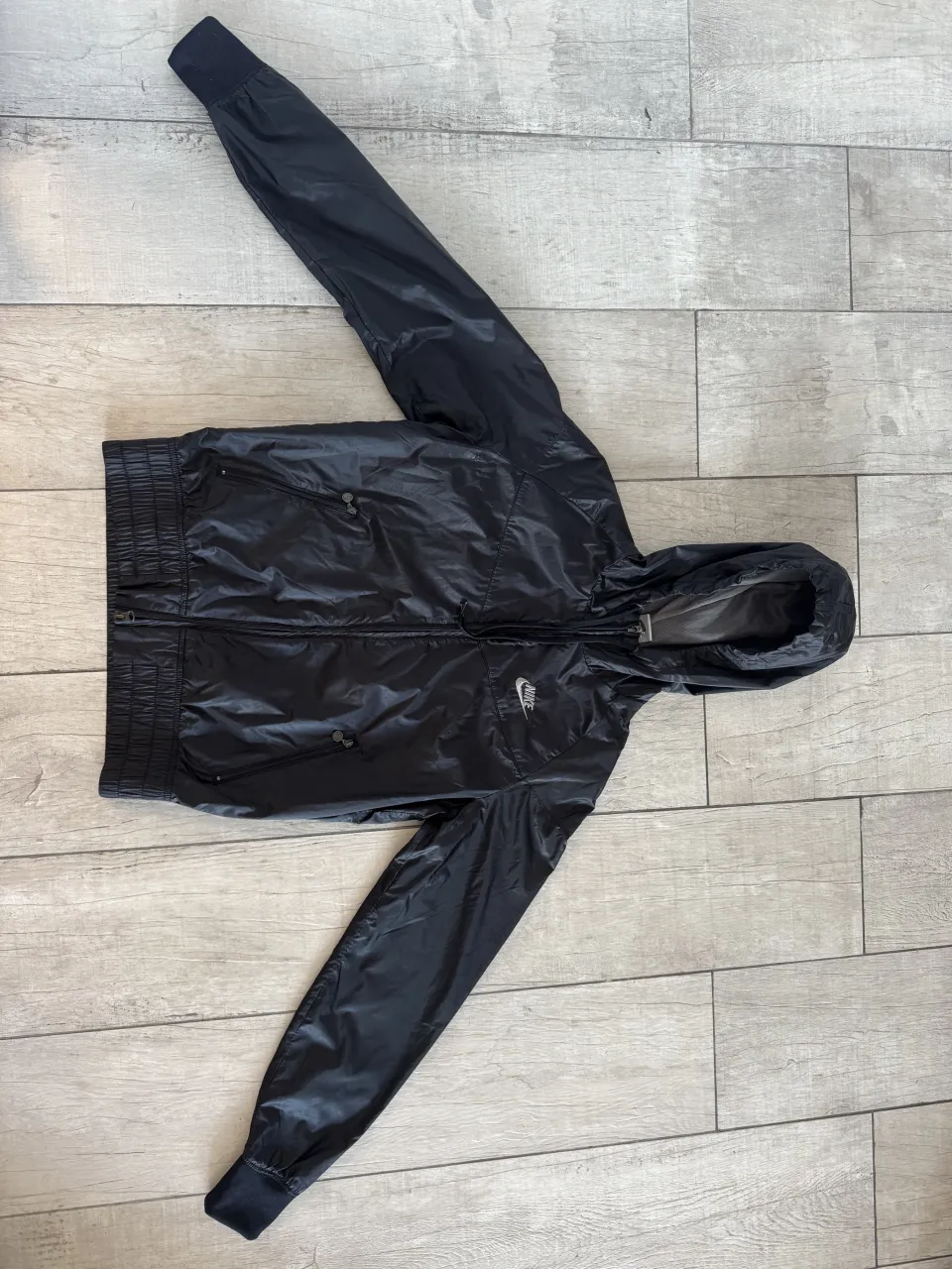 Campera deportiva negra con capucha y cierre. Posee puños y cintura elastizados. Logo de la marca bordado en el frente.