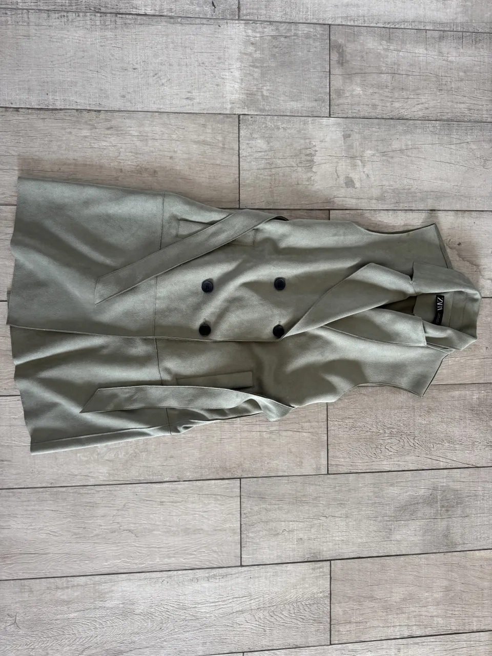 Chaleco sastrero de color verde pálido, con doble abotonadura y cinturón de tela para anudar.