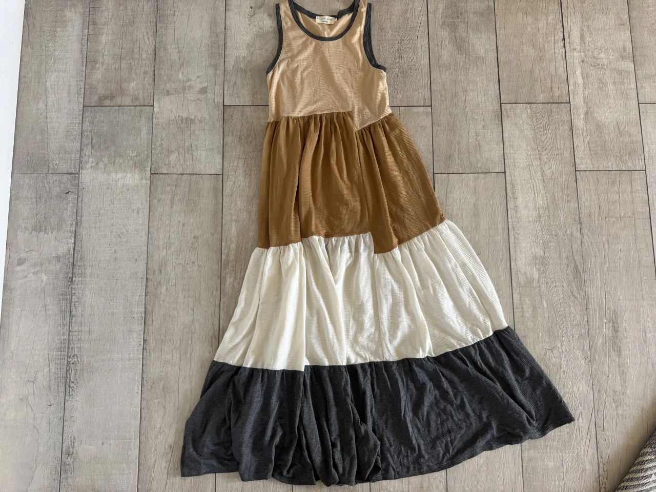 Vestido largo de tirantes con bloques de color en tonos beige, marrón, blanco y gris oscuro. Diseño con volados en la falda.