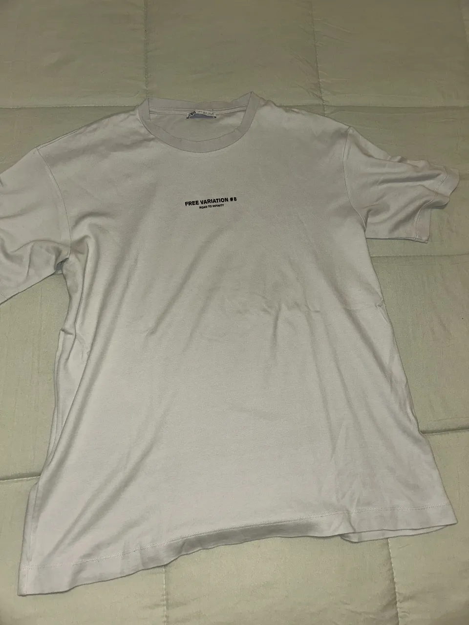 Remera blanca de hombre con estampado en el frente y la espalda. Diseño moderno y casual, ideal para un look urbano.