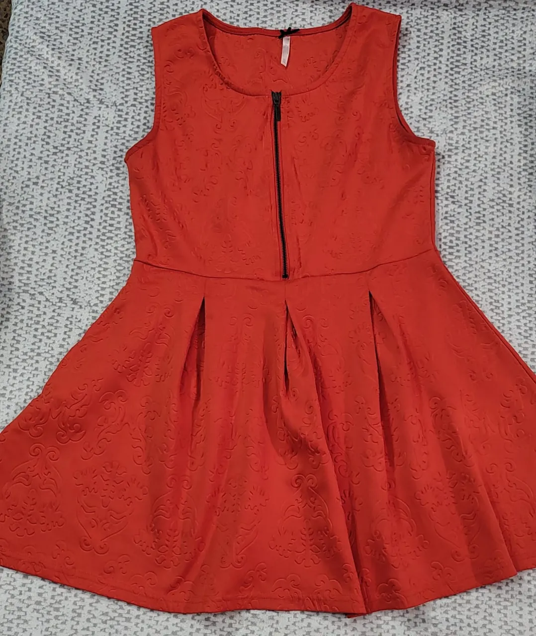 Vestido mini rojo con cierre frontal y diseño en relieve. Ideal para una salida o fiesta.
