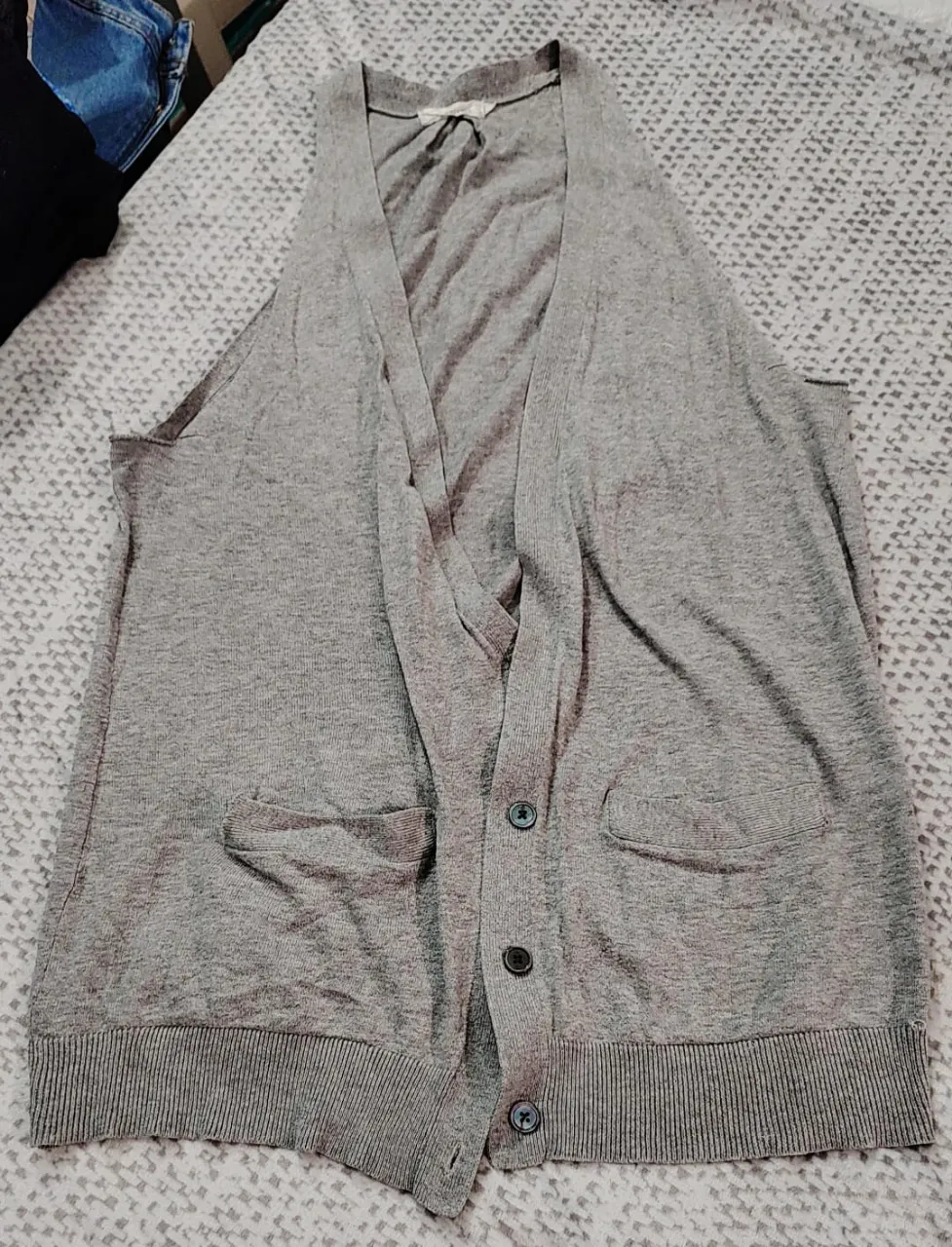 Chaleco de hombre gris con botones y bolsillos. Ideal para un look casual y cómodo.