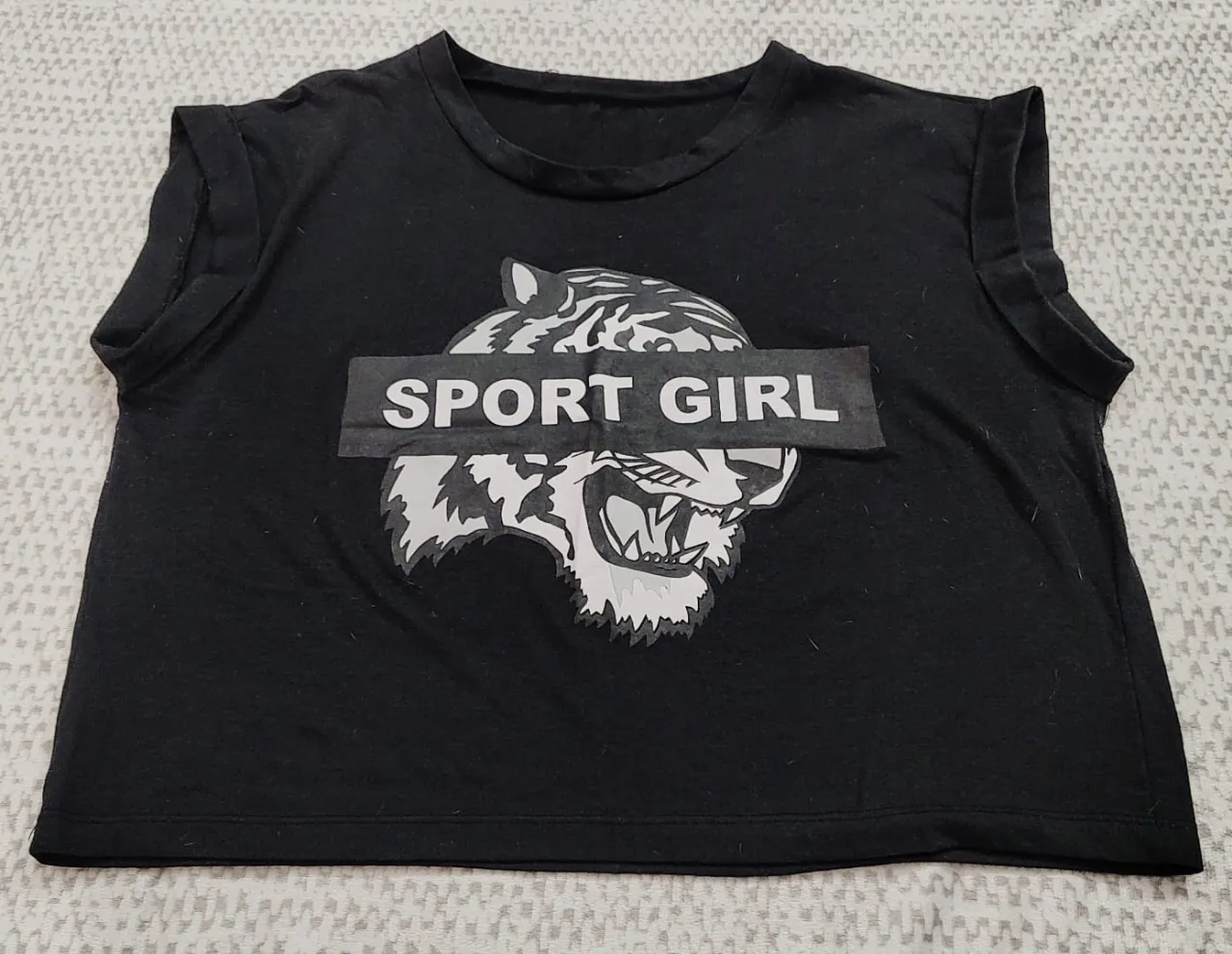 Musculosa negra de mujer con estampado de tigre y la frase "SPORT GIRL". Ideal para actividades deportivas o un look casual.