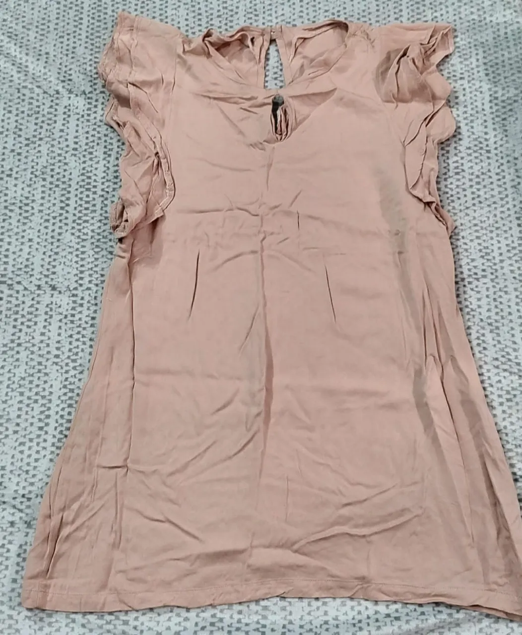 Vestido mini de color rosa, con detalles de volados en las mangas y un corte en la espalda. Ideal para una salida casual o una ocasión especial.