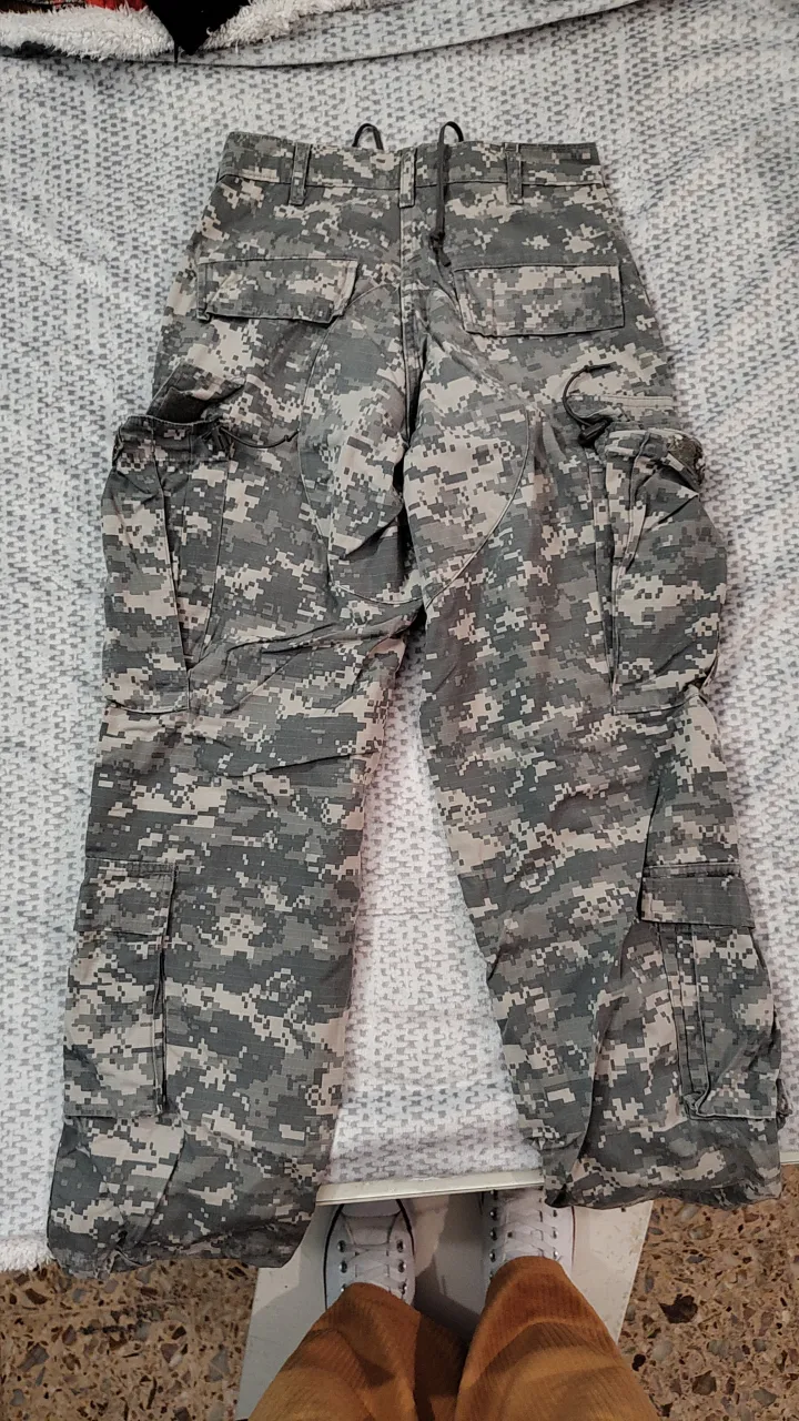 Pantalón cargo camuflado para hombre, con múltiples bolsillos y ajuste en los tobillos. Ideal para actividades al aire libre o un look utilitario.