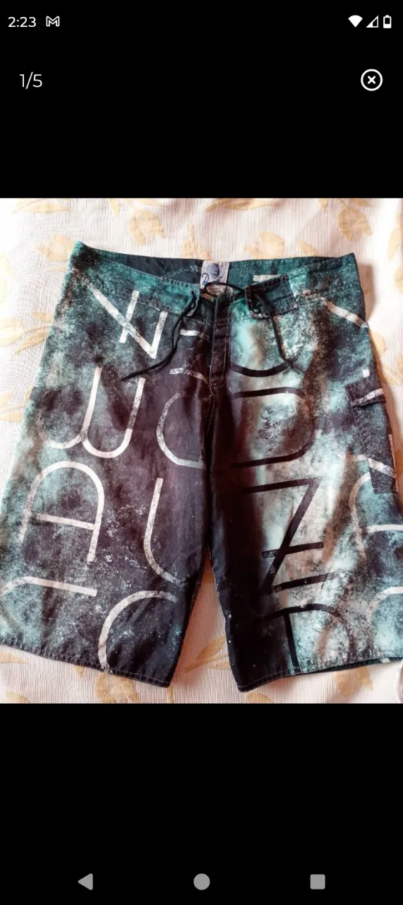 Shorts de baño con estampado abstracto en tonos verdes y blancos. Posee cordón de ajuste en la cintura y un bolsillo trasero con tapa. EXCELENTE ESTADO