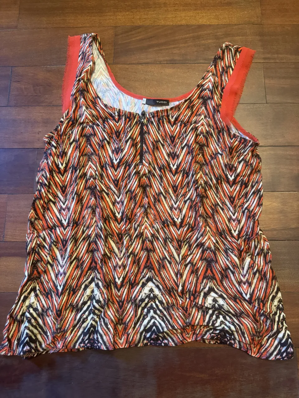 Musculosa estampada con cierre en el frente. Diseño vibrante y moderno, ideal para un look casual y canchero. Impecable 