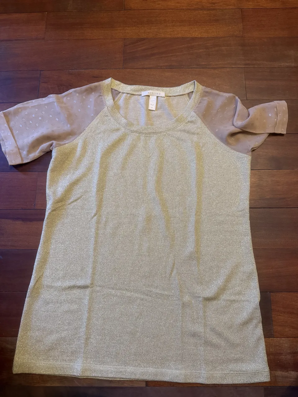 Remera de lured con brillos y mangas de gasa con detalles de puntitos. Ideal para un look elegante y moderno.