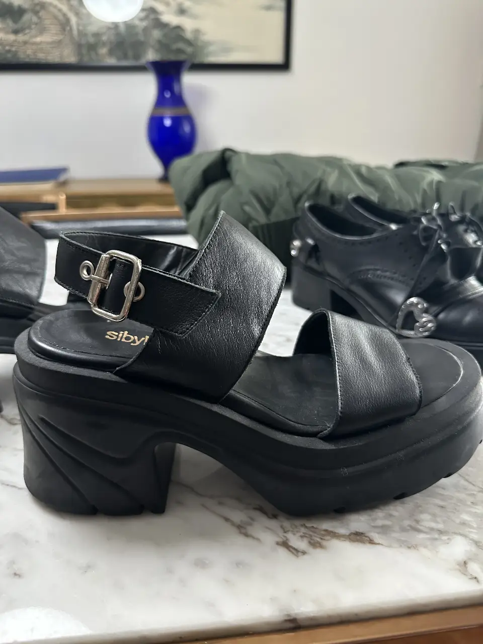 Sandalias negras con plataforma y taco ancho. Diseño con dos tiras en la parte superior y hebilla ajustable en el tobillo. Marca 'sibyl vane' en la plantilla.