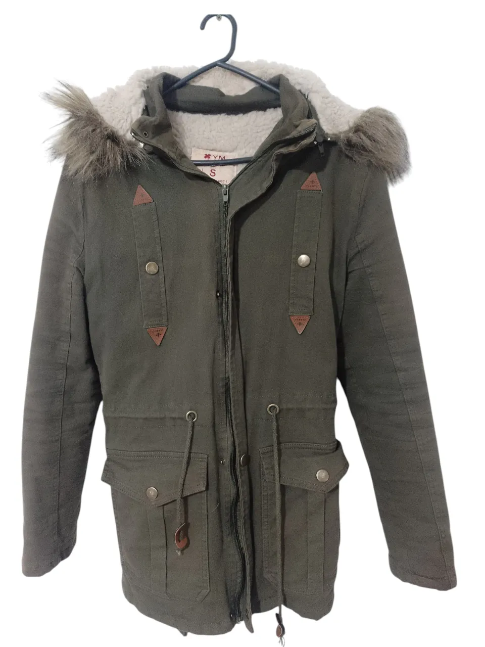 Campera de abrigo para mujer, estilo parka, color verde oscuro con capucha y borde de piel sintética marrón. Posee cierre y bolsillos amplios. Ideal para el invierno.