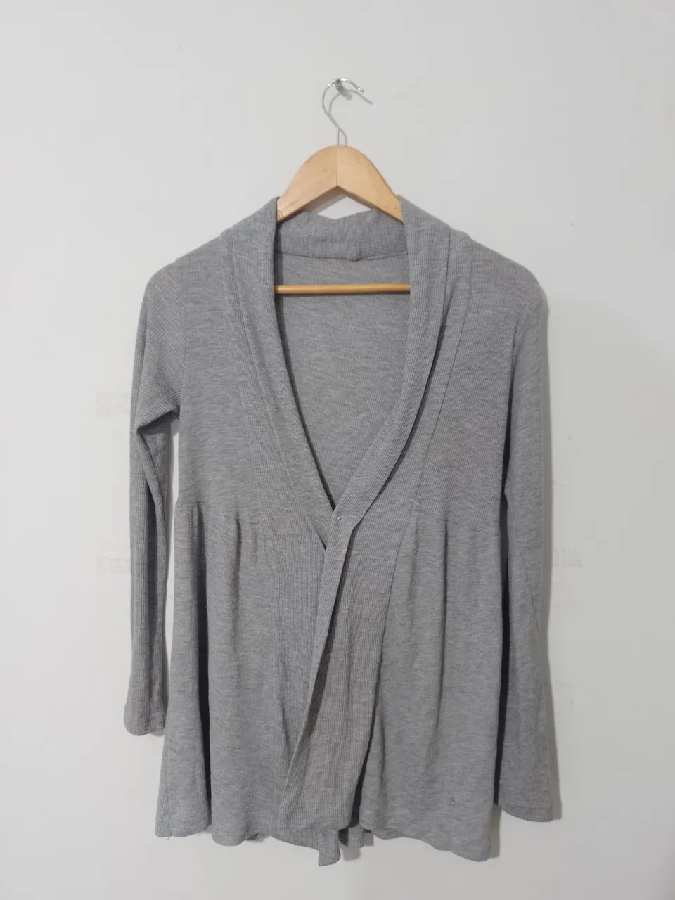 Cardigan de mujer gris, con cuello en V y corte en la cintura. Ideal para un look casual y cómodo.
