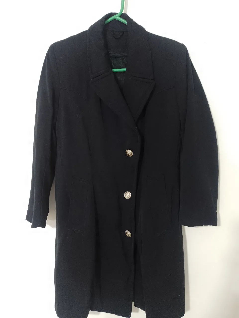 Sobretodo negro de paño con botones dorados. Ideal para un look elegante y sofisticado.