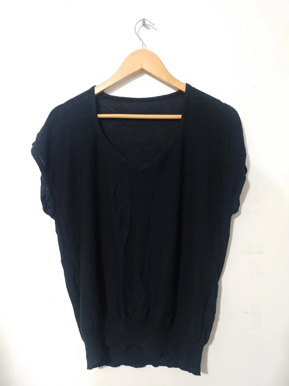 Blusa negra de manga corta con cuello en V, ideal para un look casual y elegante. Perfecta para combinar con pantalones o faldas.