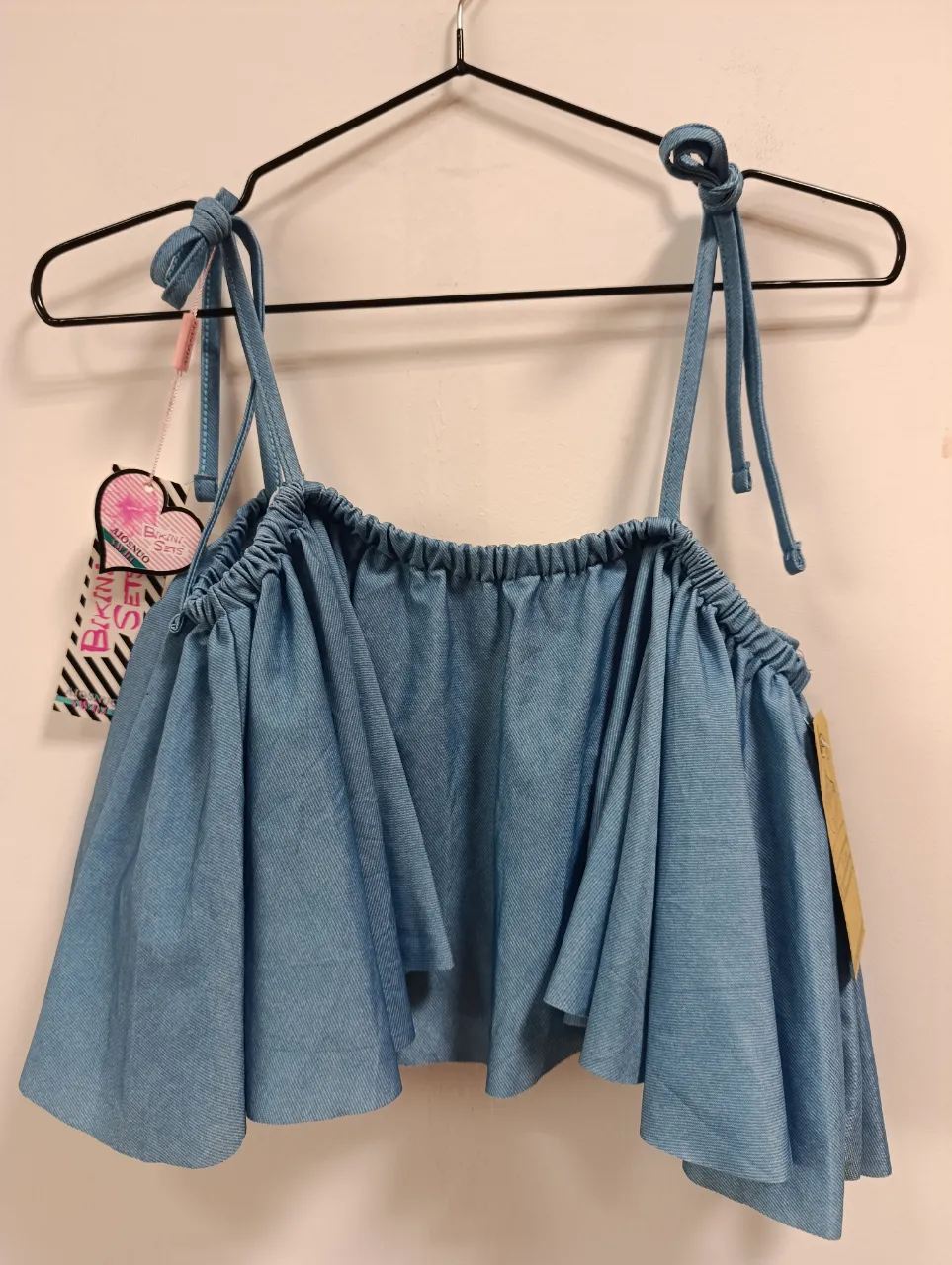 Top/bikini con volados y tiras para atar en los hombros. Ideal para un look playero o casual de verano.