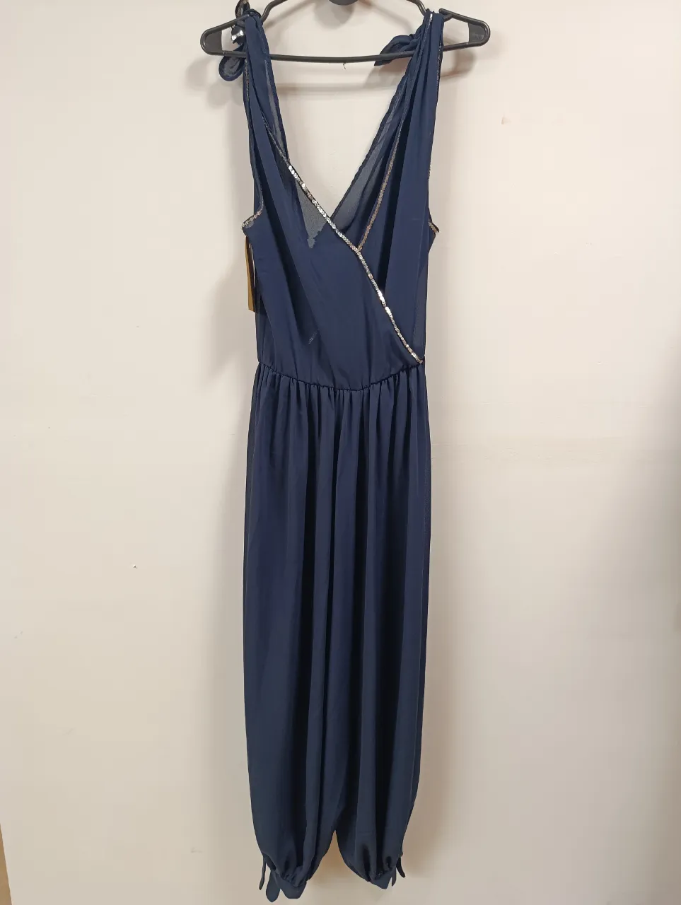 Mono largo azul marino con detalles de lentejuelas plateadas en el escote cruzado. Posee la cintura elastizada y las botamangas ajustadas con lazo. Ideal para una salida o fiesta.