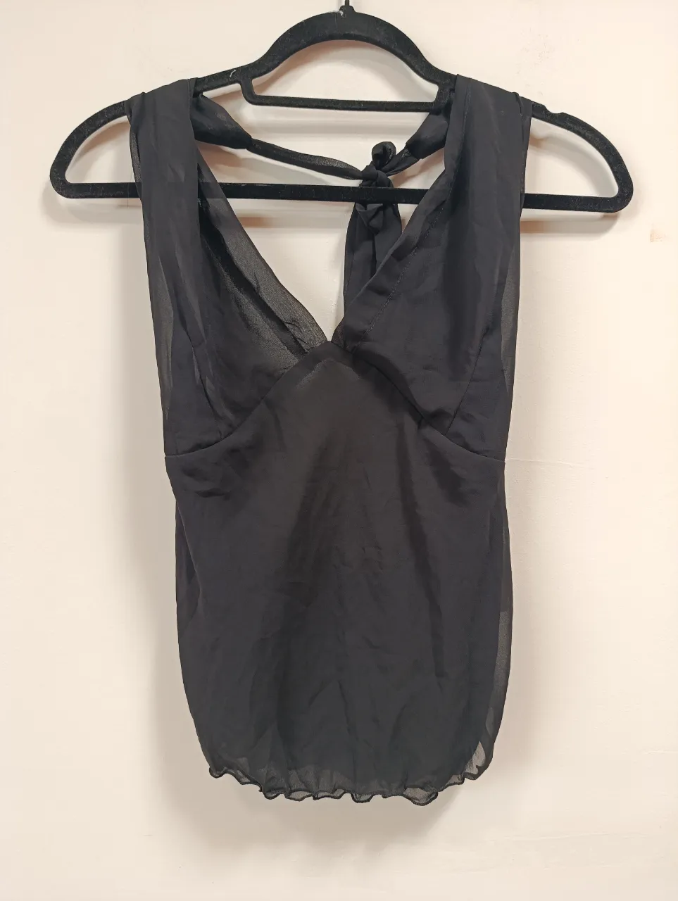 Top negro escotado con tiras para atar en la espalda. Ideal para un look canchero y sensual.