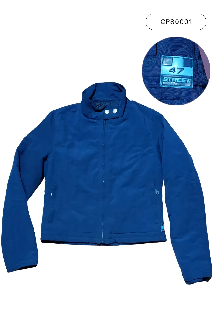 Campera "47 Street"  azul oscuro con cuello mao y cierre al frente. Posee dos bolsillos laterales con cierre y detalle de logo en la manga izquierda. El interior es negro y relleno con fibra sintética.
Medidas:
(1) 61 cm
(2) 46 cm