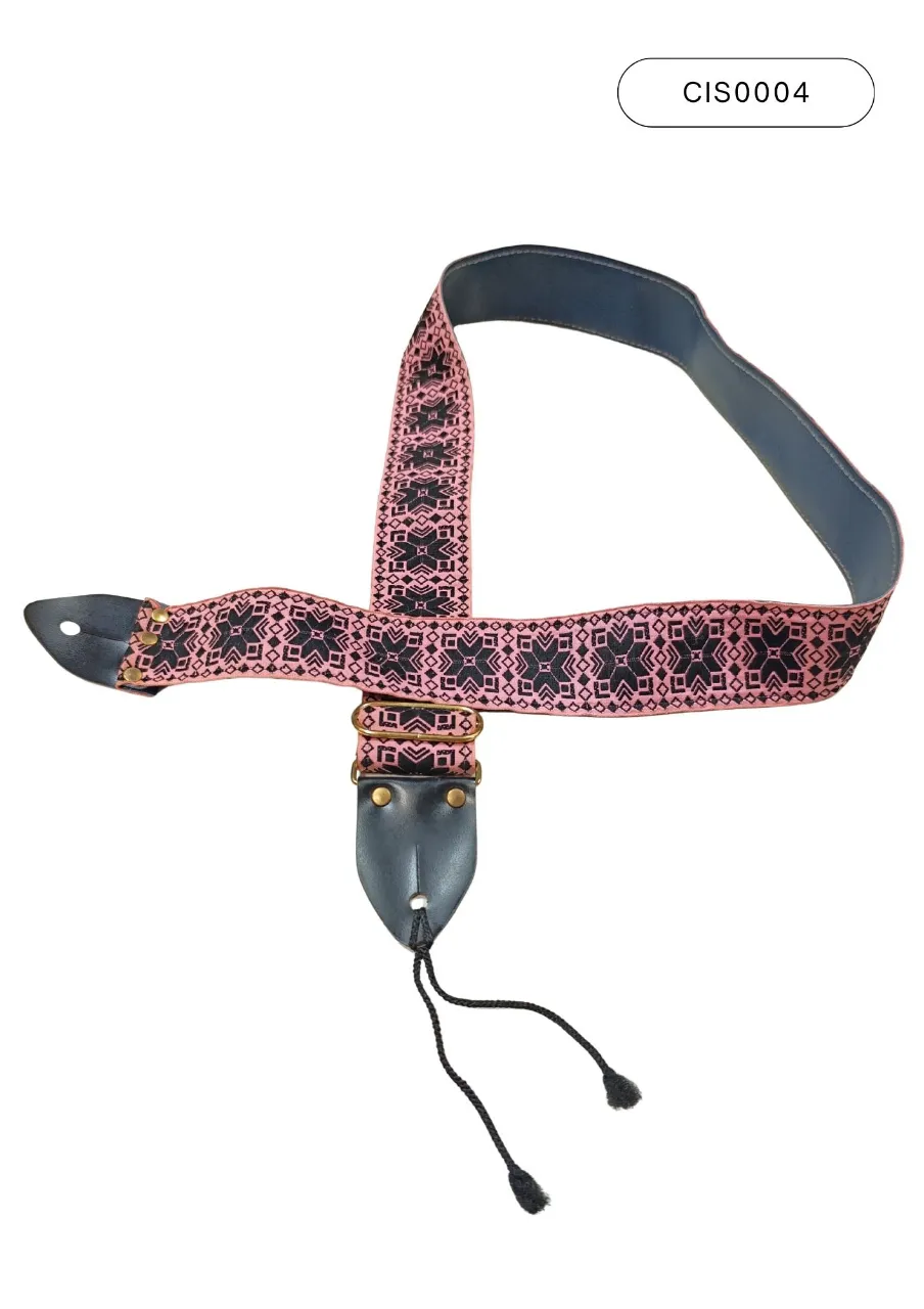 Correa para guitarra con diseño geométrico en rosa y negro. Posee detalles de cuero negro y cordones para ajuste. Largo de 112 cm.