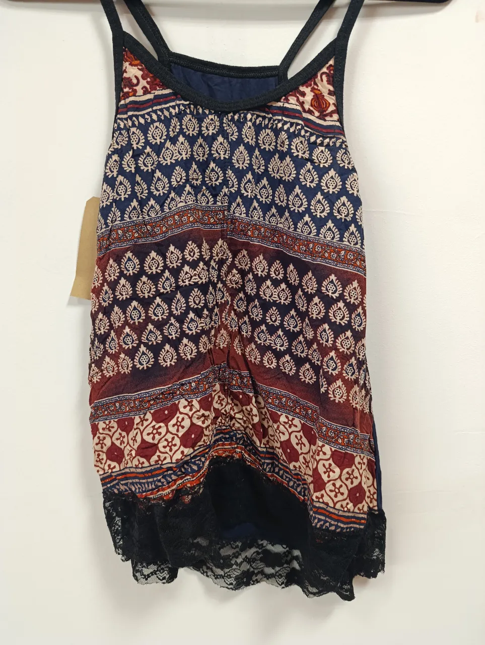 Musculosa boho con estampado floral y detalles de encaje negro en el ruedo. Ideal para un look relajado y con estilo.