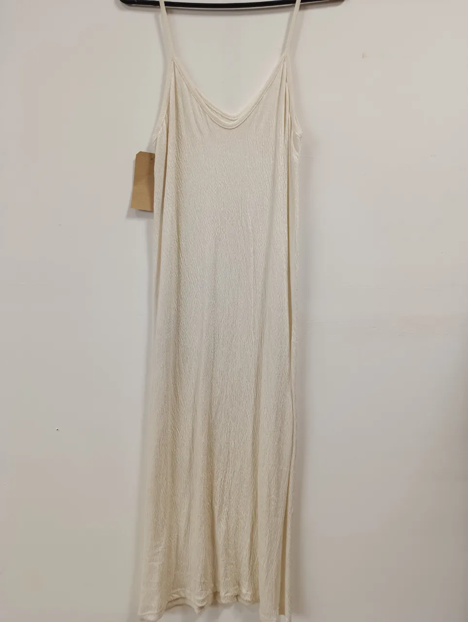 Vestido largo de tirantes finos, color crudo, con textura sutil y tajo lateral. Ideal para un look fresco y relajado.