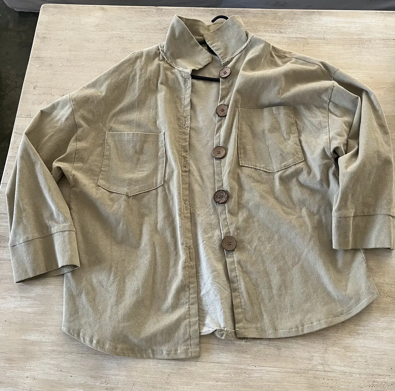Camisa de corderoy color verde seco, con cuello alto y botones grandes. Corte oversize con mangas caidas