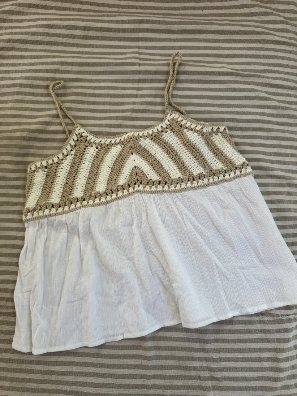 Musculosa blanca con detalles de crochet en la parte superior en color crudo y blanco. Posee tiras finas.