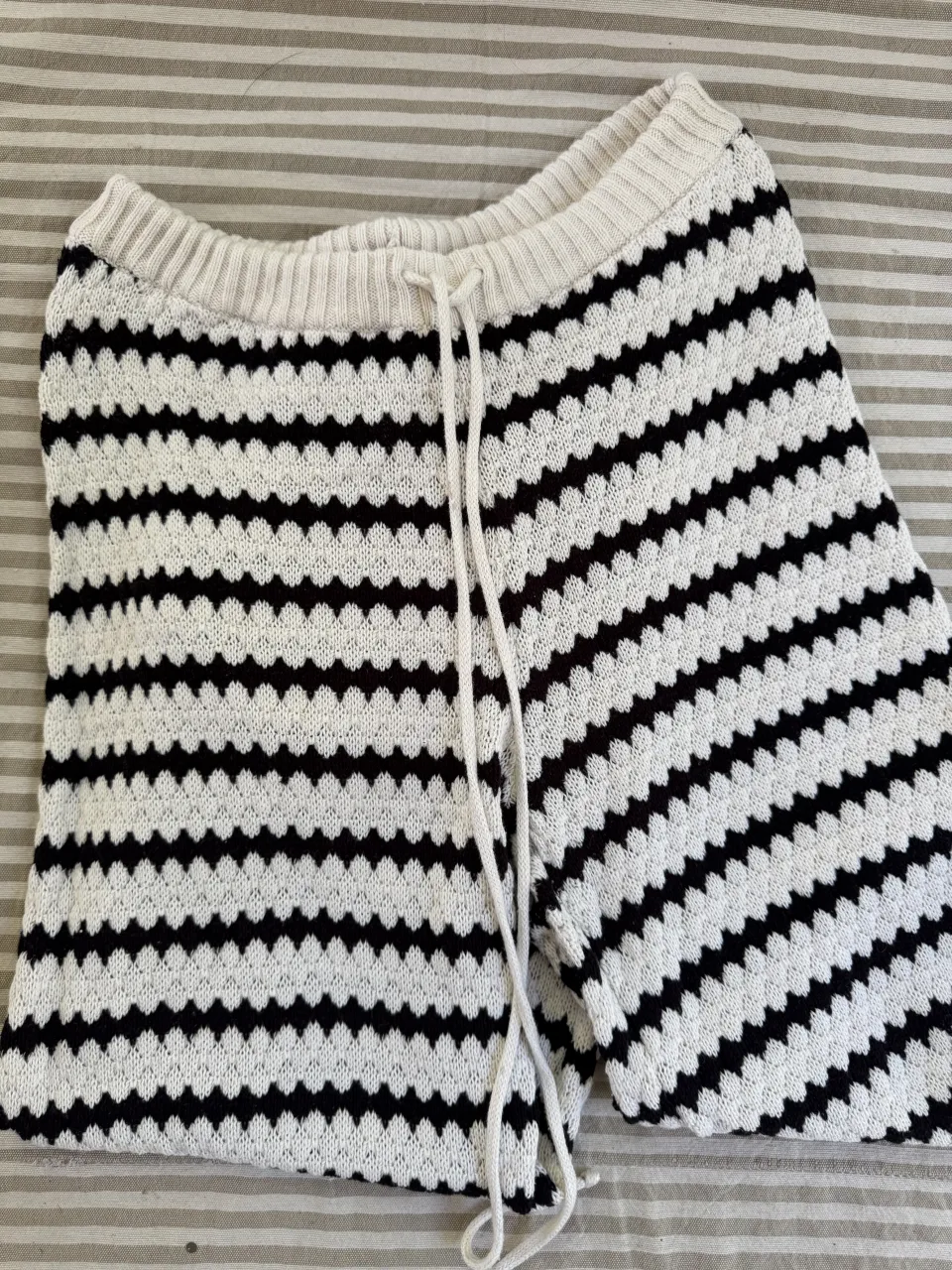 Pantalón tejido a rayas blancas y negras con cordón en la cintura.