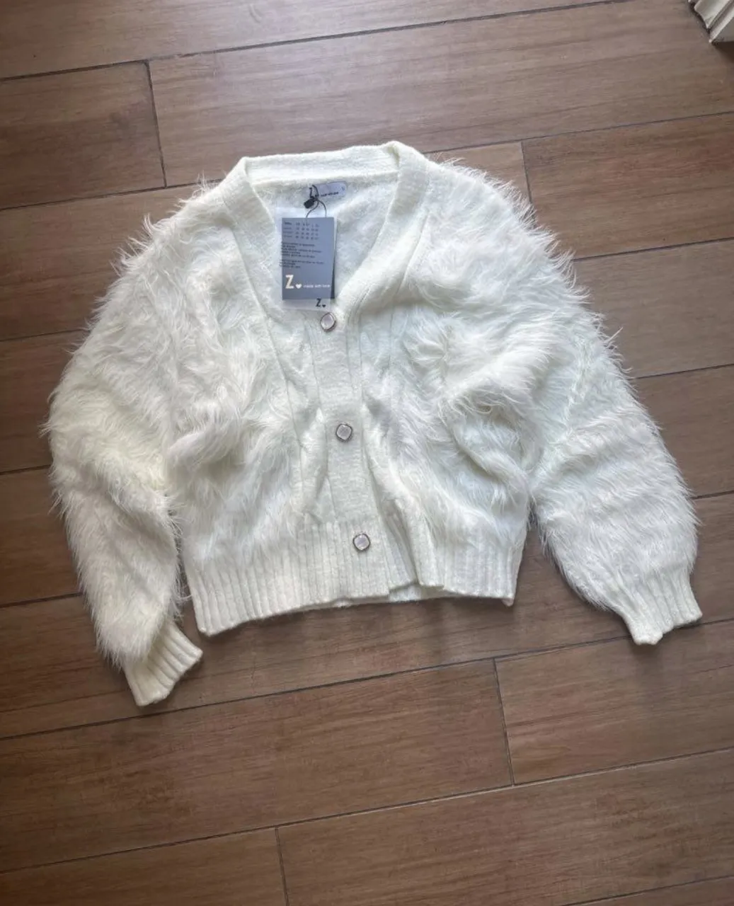 nuevo con etiqueta, marca Zoom super suavecito! Cardigan blanco de tejido suave con botones nacarados y detalles de pelo sintético en las mangas y el frente. Posee cuello en V y puños tejidos.