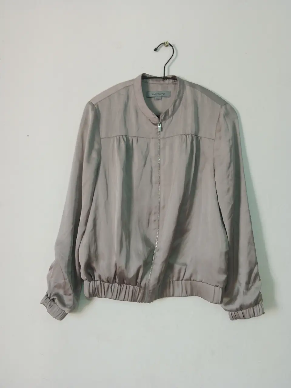 Campera bomber de mujer, color gris, con cierre frontal y puños elastizados. Ideal para un look casual y moderno.