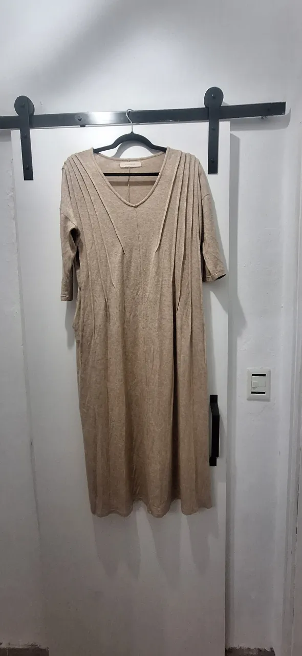 Vestido midi de tejido suave en color crudo, con escote en V y detalles plisados en la parte superior, con bolsillos.Ideal para un look casual y cómodo