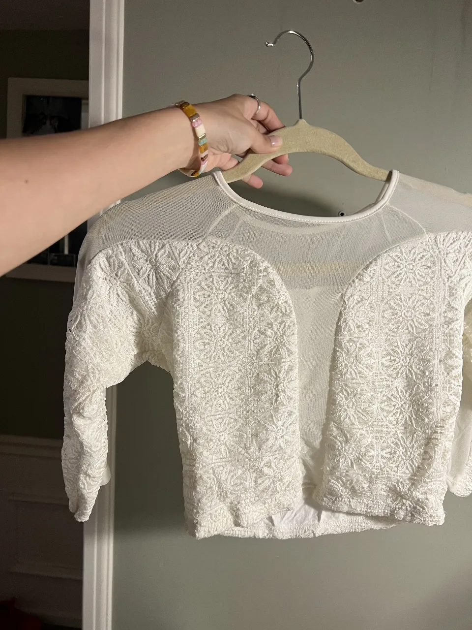 Blusa blanca de manga larga con detalles de encaje y transparencias. Un diseño delicado y romántico, perfecto para un look elegante o para darle un toque especial a un outfit casual.