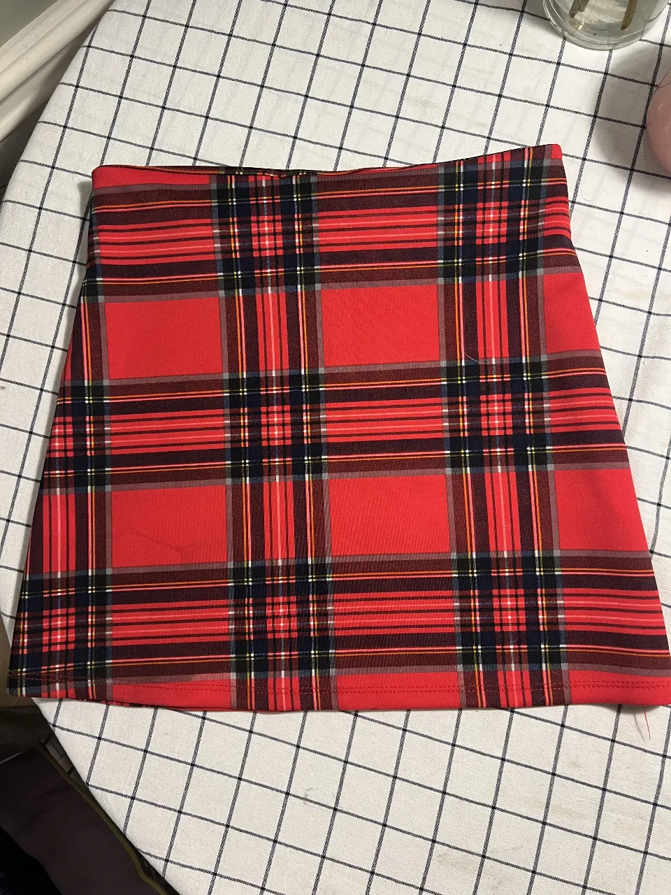 Pollera corta a cuadros escoceses en rojo, negro y blanco. Ideal para un look casual o preppy.