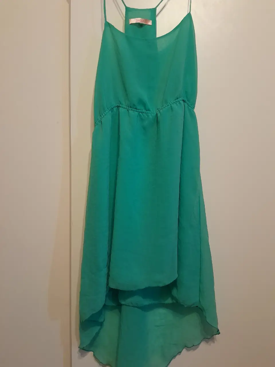 Vestido midi de gasa en color verde esmeralda, con detalle fruncido en la cintura y tirantes finos. Ideal para eventos de verano.