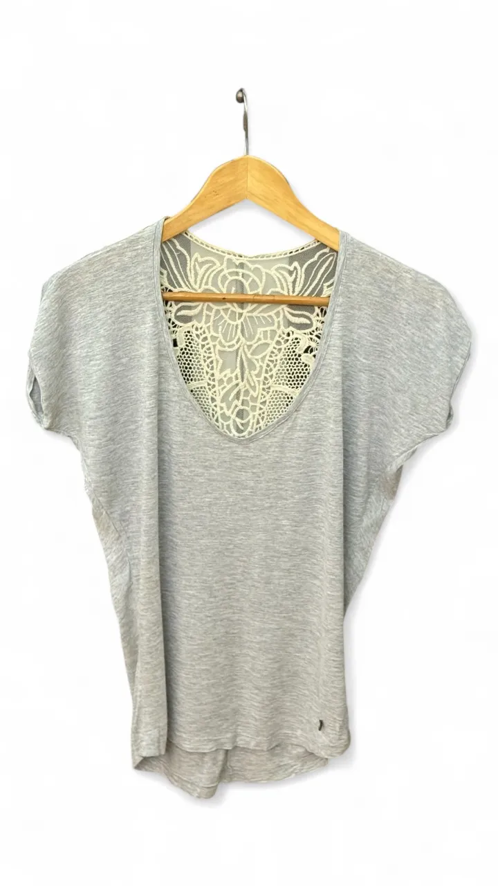 Blusa gris con espalda de encaje. Ideal para un look casual y fresco.