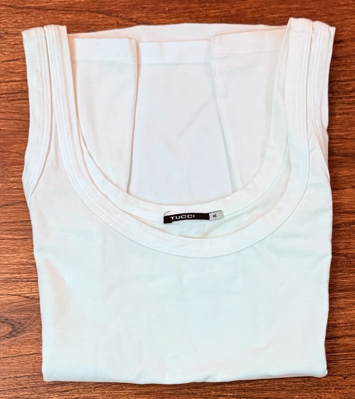 Musculosa blanca de mujer, de corte clásico y escote redondo. Ideal para combinar con cualquier outfit casual.