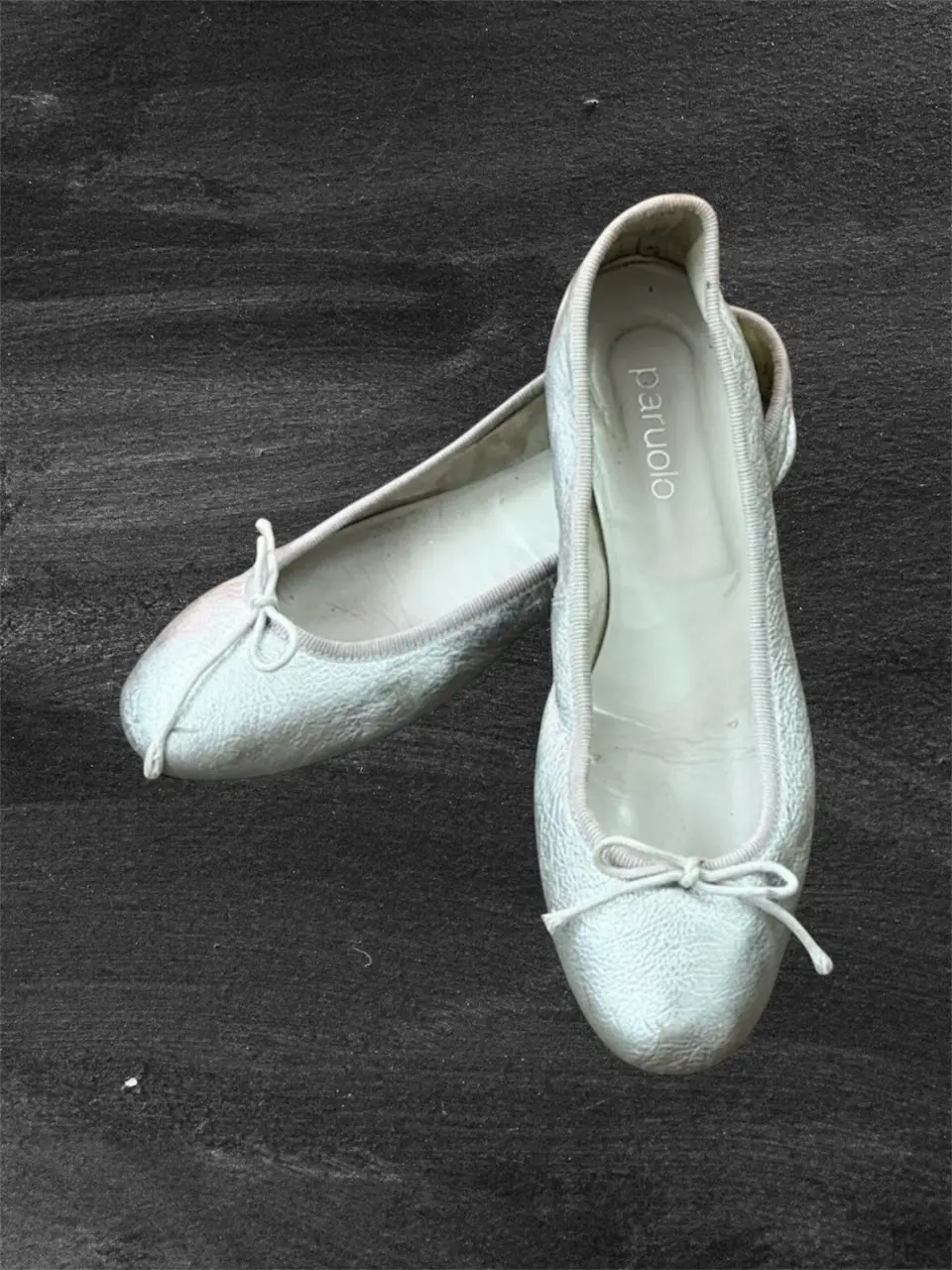 Ballerinas plateadas de mujer, con moño en la punta y detalle de costura en el borde. Ideales para un look elegante y cómodo.