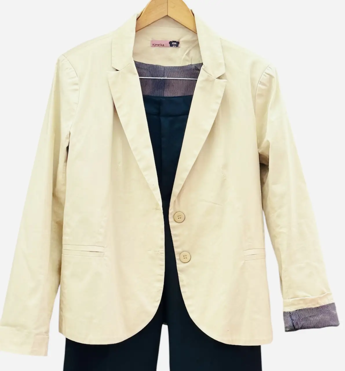 Blazer de mujer color crudo, con dos botones y bolsillos delanteros. Ideal para un look formal o casual elegante.