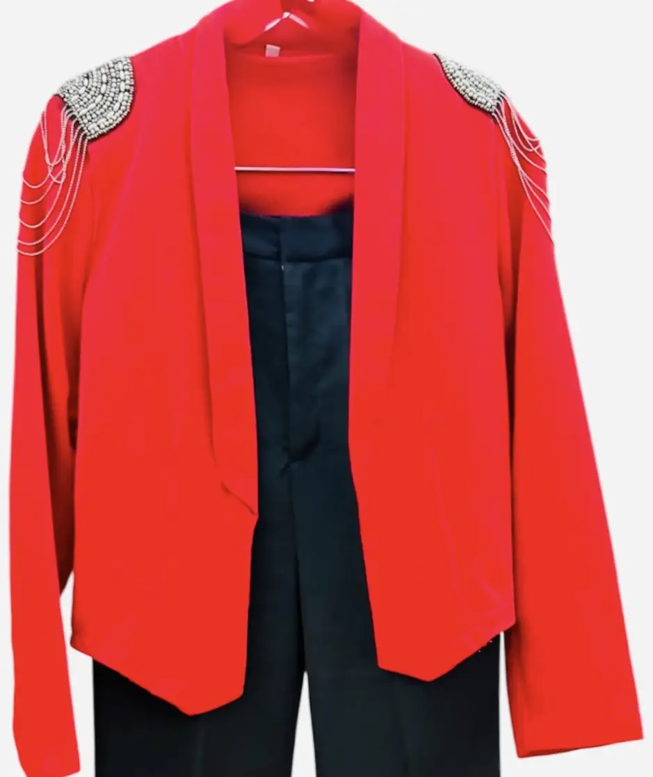 Elegante blazer rojo con detalles de hombreras adornadas con pedrería y cadenas plateadas. Ideal para eventos formales o para darle un toque sofisticado a cualquier outfit.