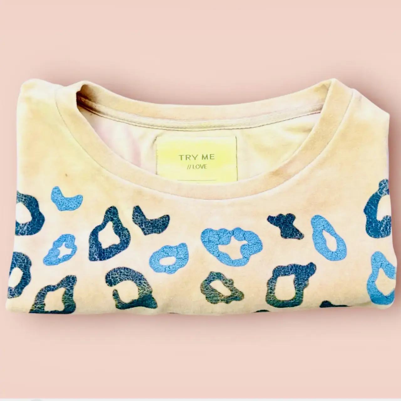 Buzo de plush rosa claro,cuello redondo con estampado de manchas de leopardo en tonos azules y beige. Ideal para un look casual y cómodo. hermoso 