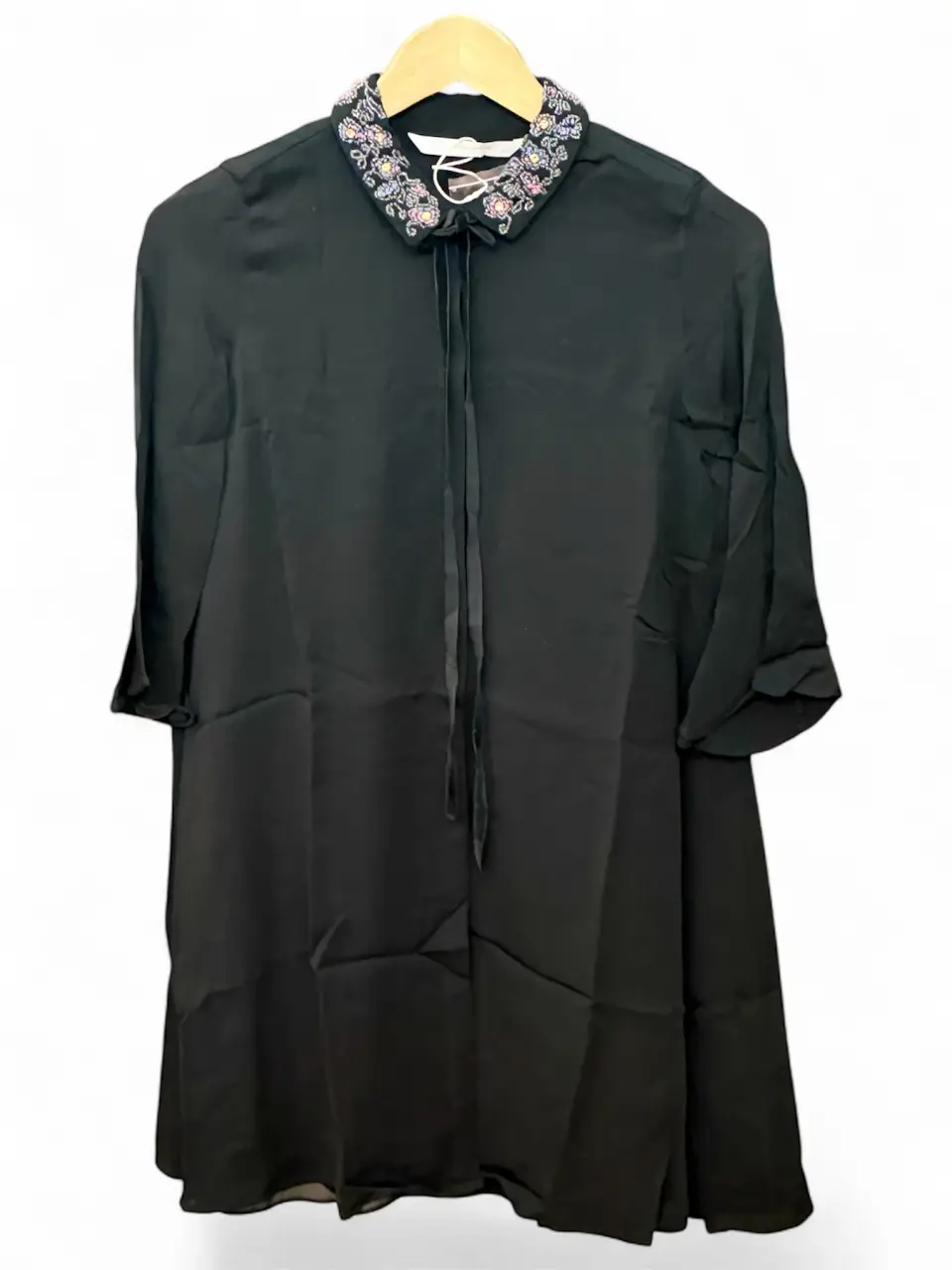 Blusa o vestido con gran movimiento . cuello bordado de canutillos puedas y detalle de cinta. Ideal para un look elegante y sofisticado.