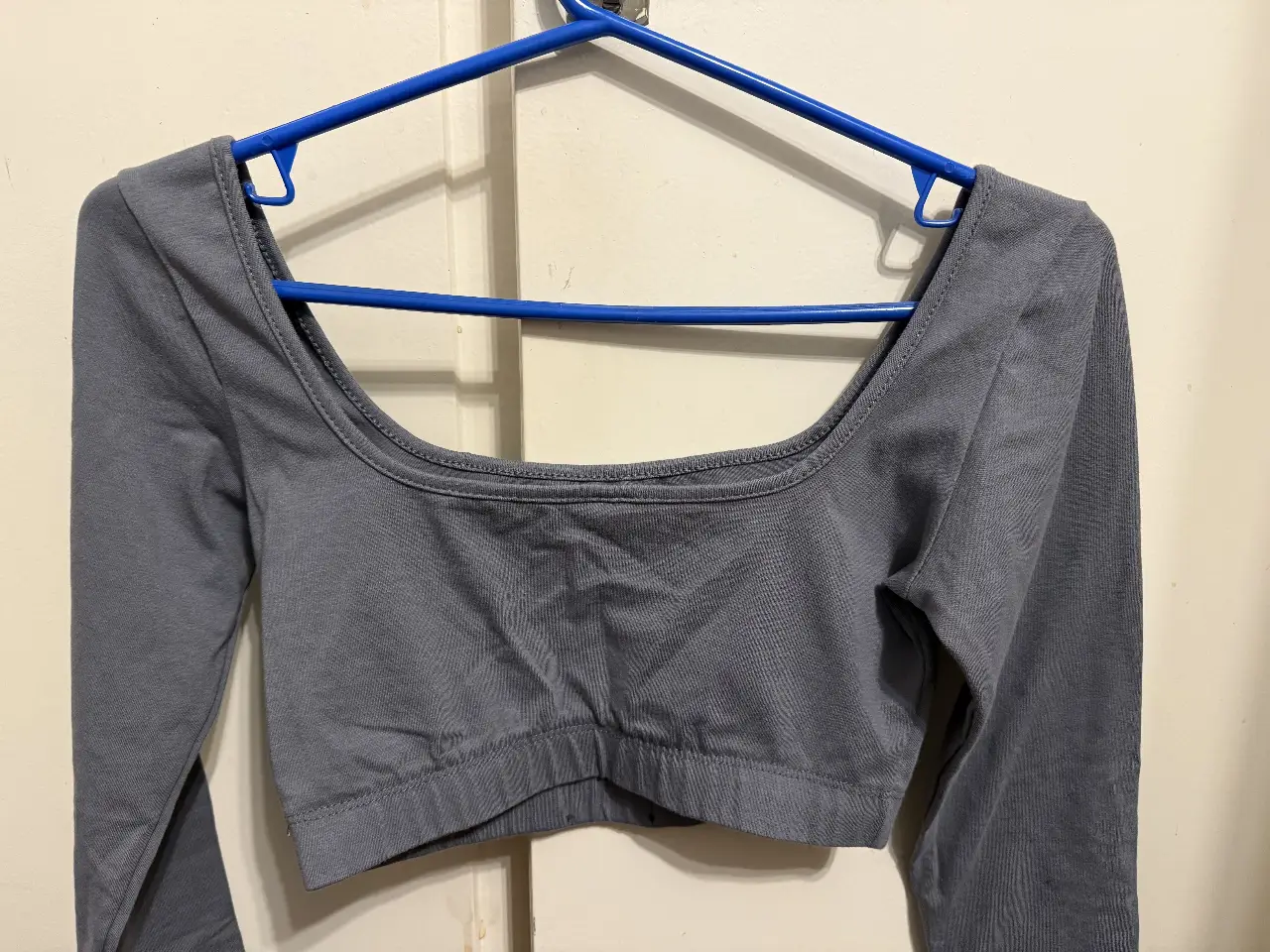 Top manga larga gris, ideal para un look casual y cómodo. Perfecto para combinar con jeans o pantalones de vestir.