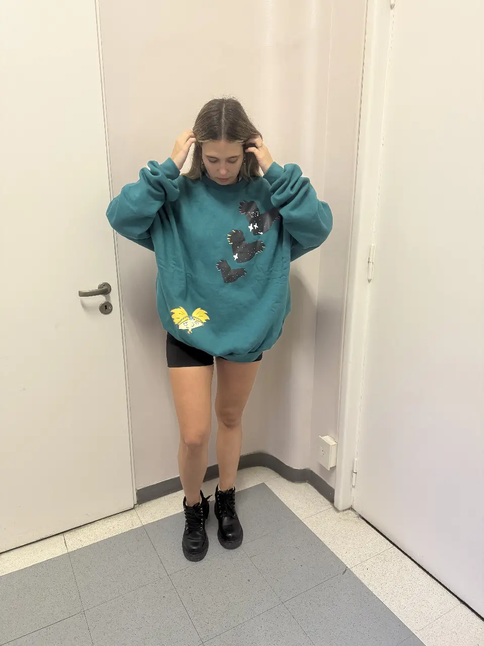 Buzo de cuello redondo de color verde con estampado de personajes de dibujos animados. Ideal para un look casual y cómodo. Varios talles 