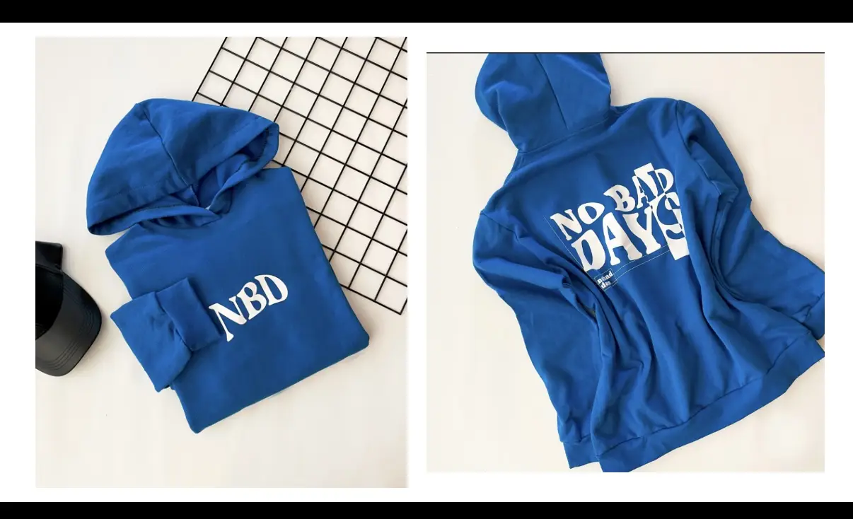 Buzo canguro azul con capucha y estampado "NBD" en blanco en el frente y "NO BAD DAYS" en la espalda. Ideal para un look casual y cómodo. varios talles 