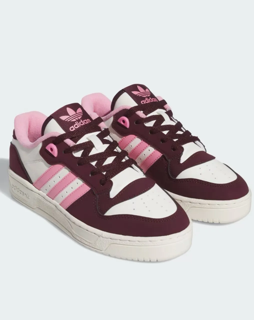 Zapatillas Adidas Rivalry Low para mujer. Diseño en blanco y rosa con detalles en borgoña. Ideales para un look casual y urbano.

(90.000)