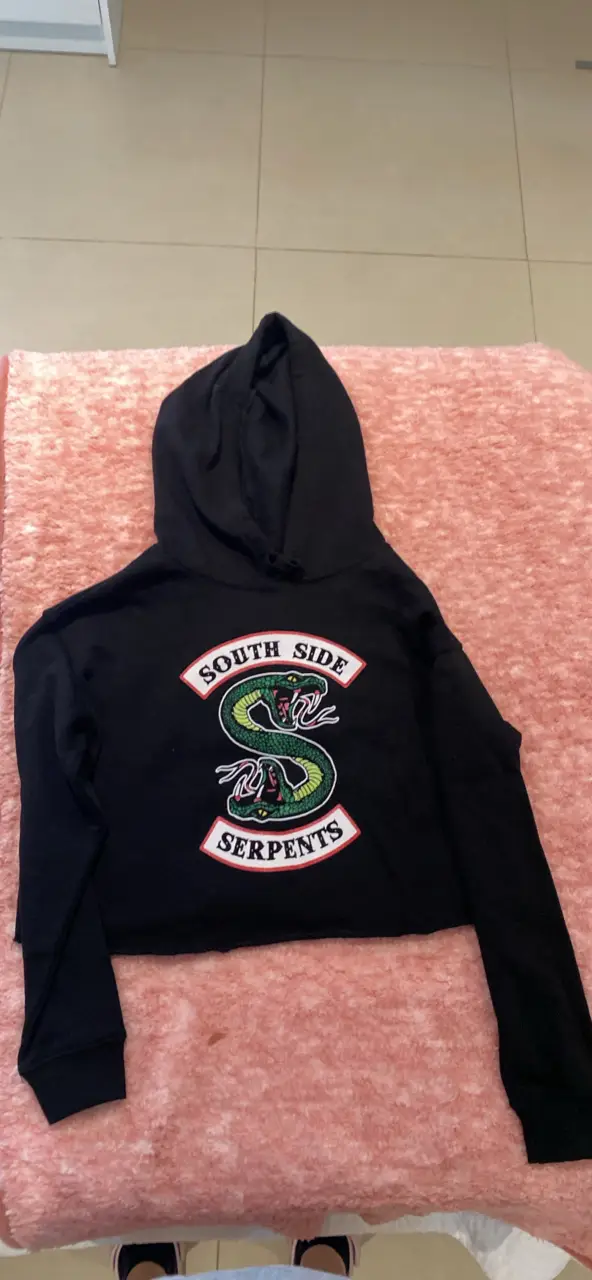 Buzo crop negro con el logo de South Side Serpents estampado en el frente. Ideal para un look casual y urbano, perfecto para fans de la serie Riverdale.