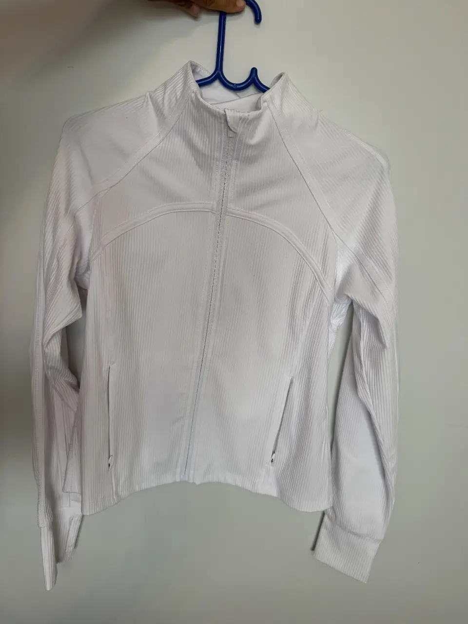 Campera deportiva blanca de la marca Danskin, con cierre frontal y detalles acanalados. Ideal para actividades físicas o un look casual.