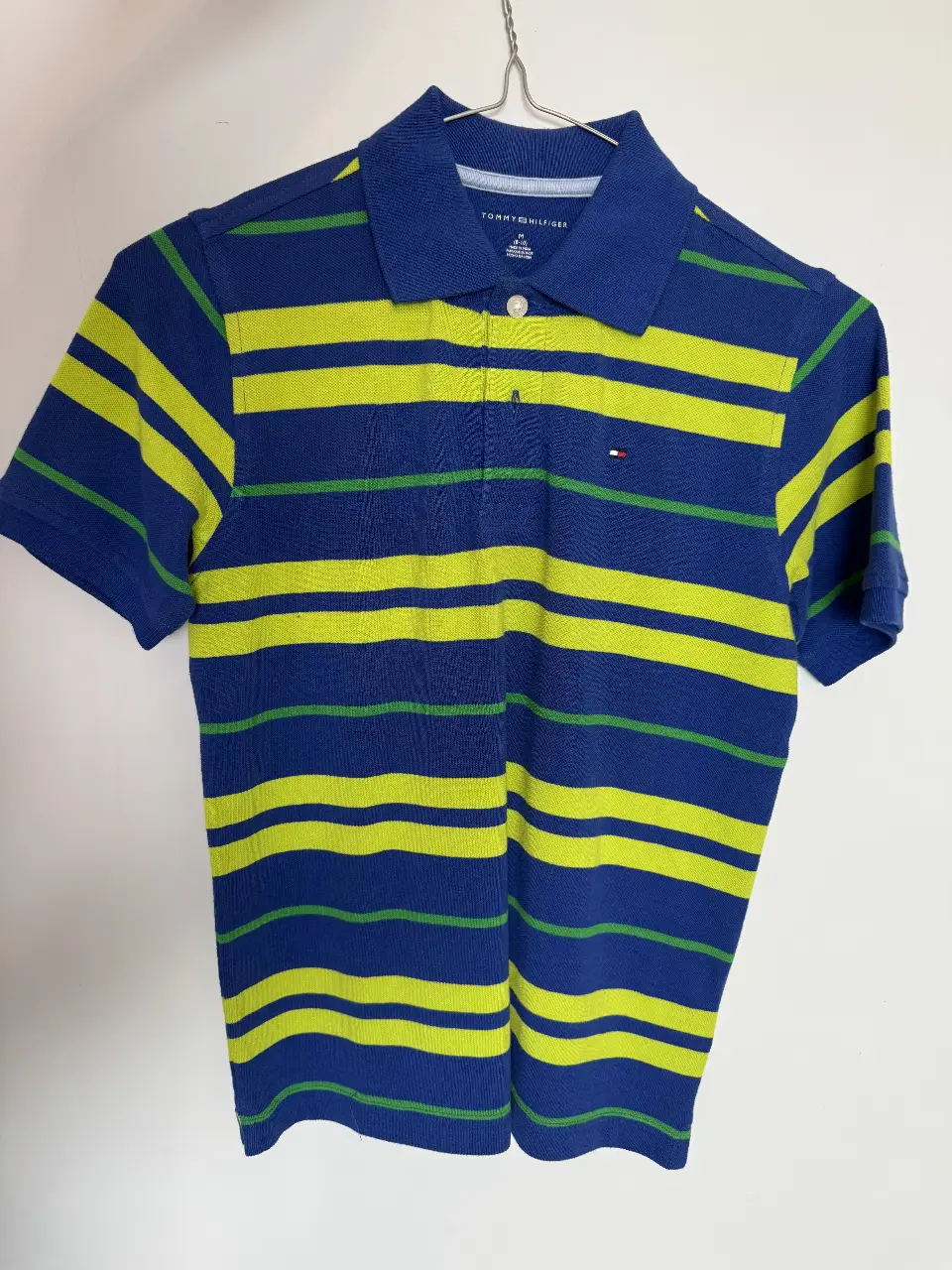 Remera polo Tommy Hilfiger para niño, a rayas azul y amarillo, con el logo de la marca bordado. Ideal para un look casual y deportivo.