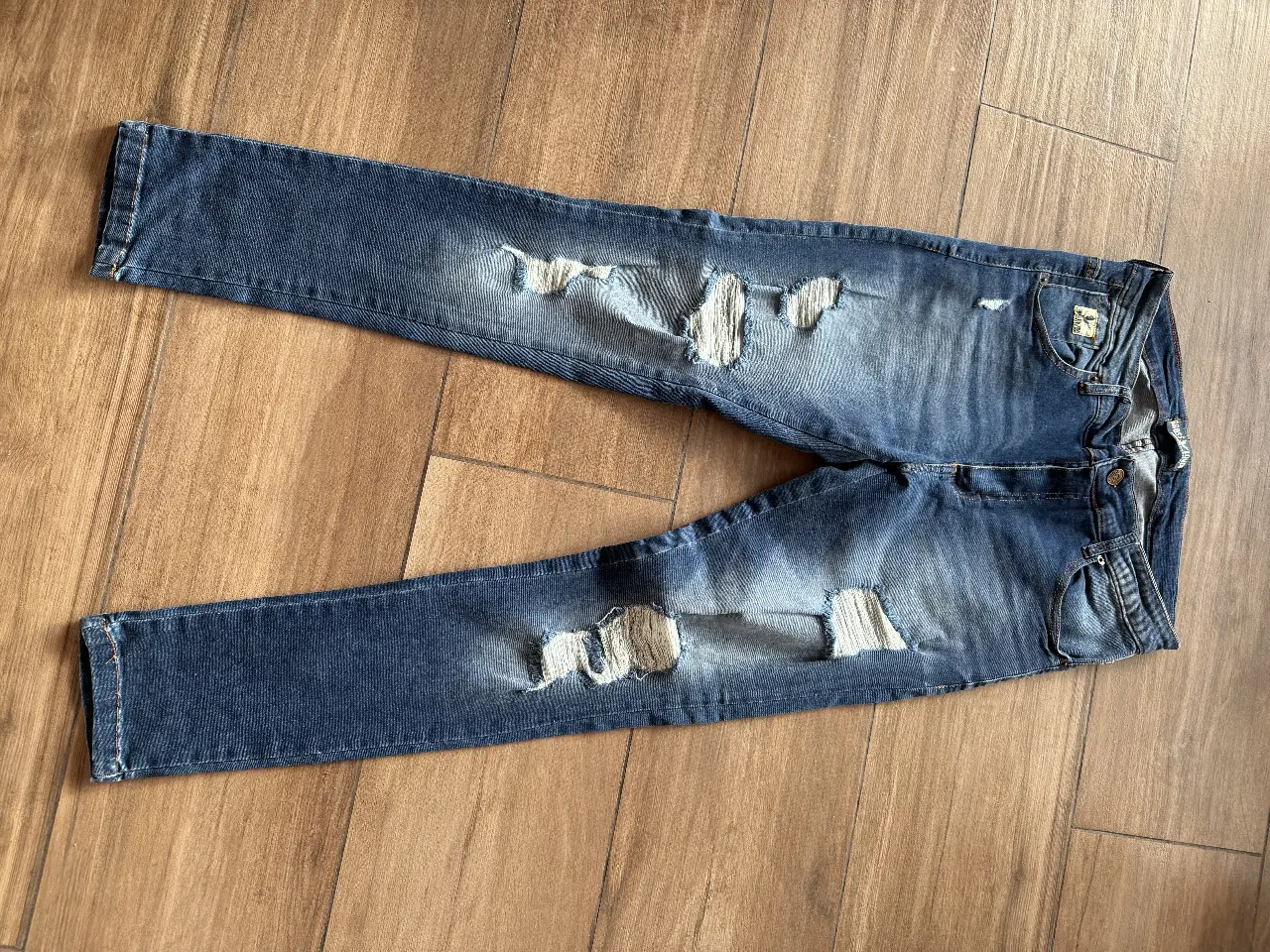 Jeans de hombre azul con roturas, tiro medio y corte recto. Marca Bross London, talle 30.