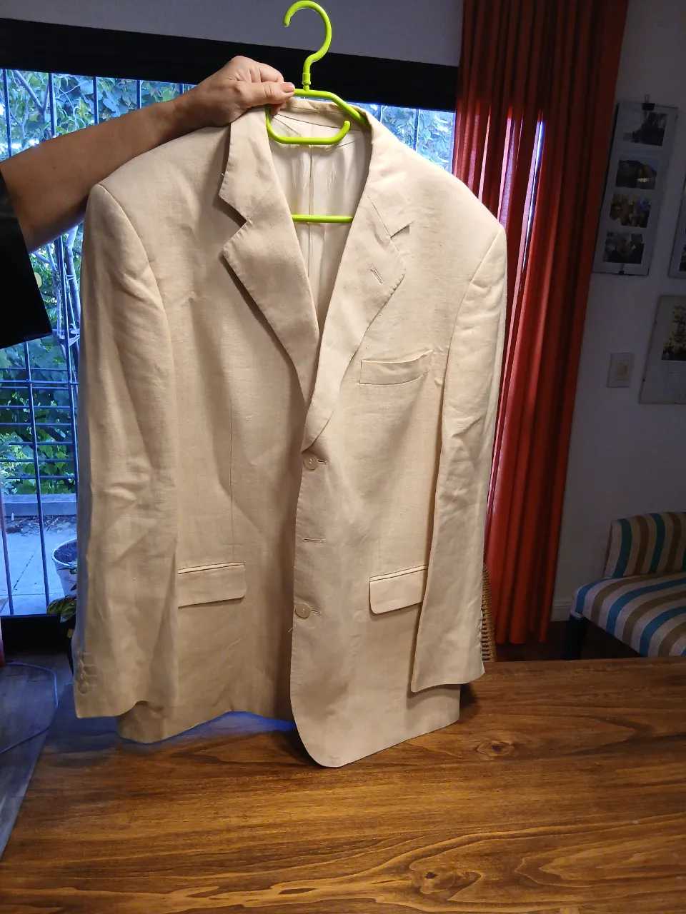 Blazer de lino color crudo, con dos botones al frente y bolsillos con solapa.